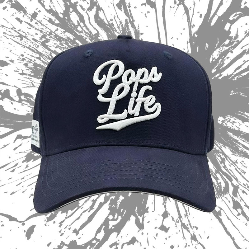 Artistic front view of Pops Life navy dad hat with splatter background, emphasizing the stylish logo.