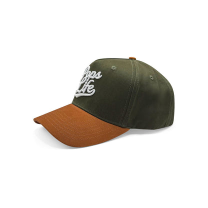 Left profile of Pops Life green and tan baseball cap with curved brim and raised logo embroidery.