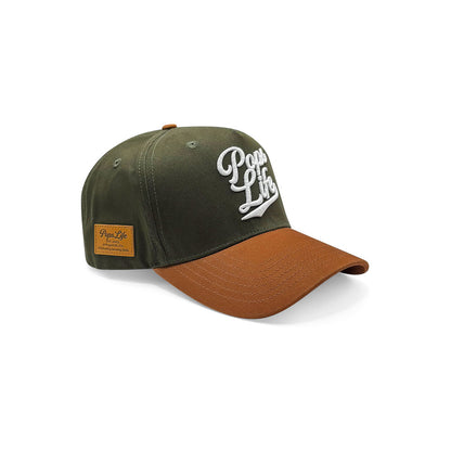 Side view of Pops Life hunter green and tan dad hat featuring embroidered logo and leather patch detail.